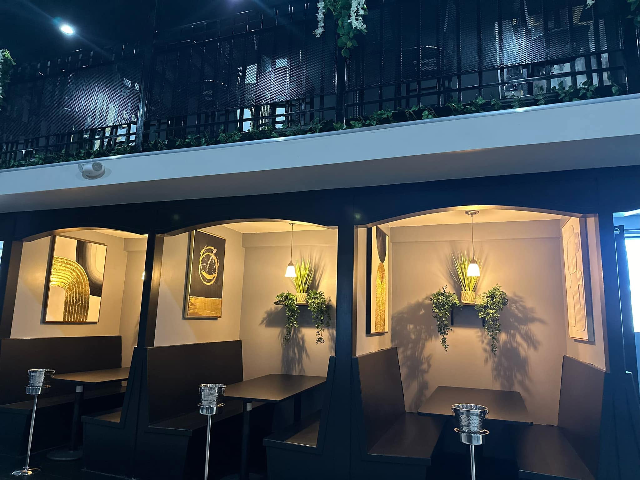 Private curved booths with warm lighting and gold art
